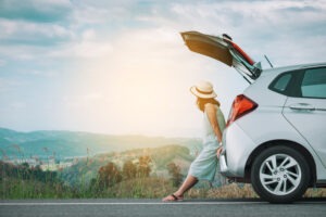 woman-leaning-on-open-car-trunk
