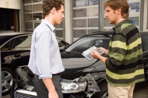 Claims Adjuster Estimating Property Loss Amount With Car Accident Victim