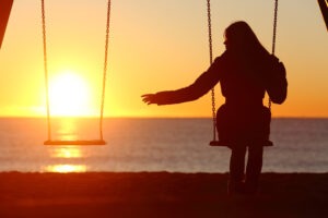 woman-reaches-for-empty-swing