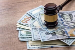 What is the average settlement for motorcycle accident lawsuits? Money is placed underneath a gavel.