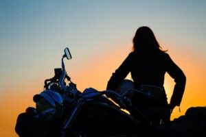 A woman rides a motorcycle.