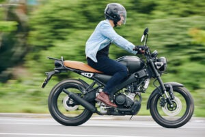 A young man rides a motorcycle.