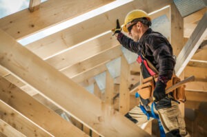 A construction worker supervises carpentry work at a worksite.