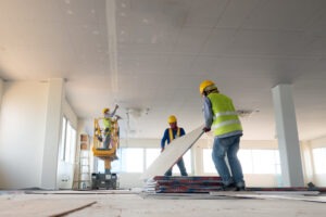 three-construction-workers-install-paneling-in-a-new-building