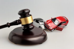 A gavel by wrecked cars. You can find out what a car accident lawyer does with our team.