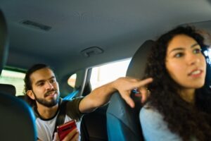 A rideshare passenger gives his driver directions to his destination.