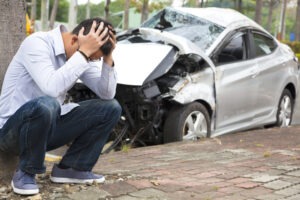 An upset man after a car accident. Determine when you should hire a lawyer after a car accident.