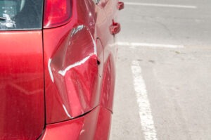 A red car was damaged in a parking lot accident in Indiana. The owner wonders what he should do after being hit in the parking lot. A personal injury lawyer will guide the vehicle's owner through the legal process.