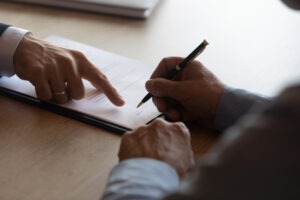 Lafayette Walmart truck accident lawyer points at paper to help client sign contingency agreement.