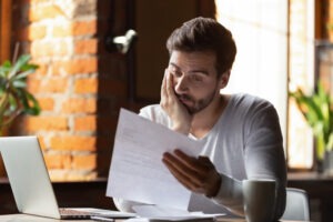 Man looks at bill from accident before calling a Lafayette FedEx truck accident lawyer.