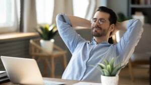 Man with glasses leaning back in relaxation at computer after calling a South Bend FedEx truck accident lawyer.