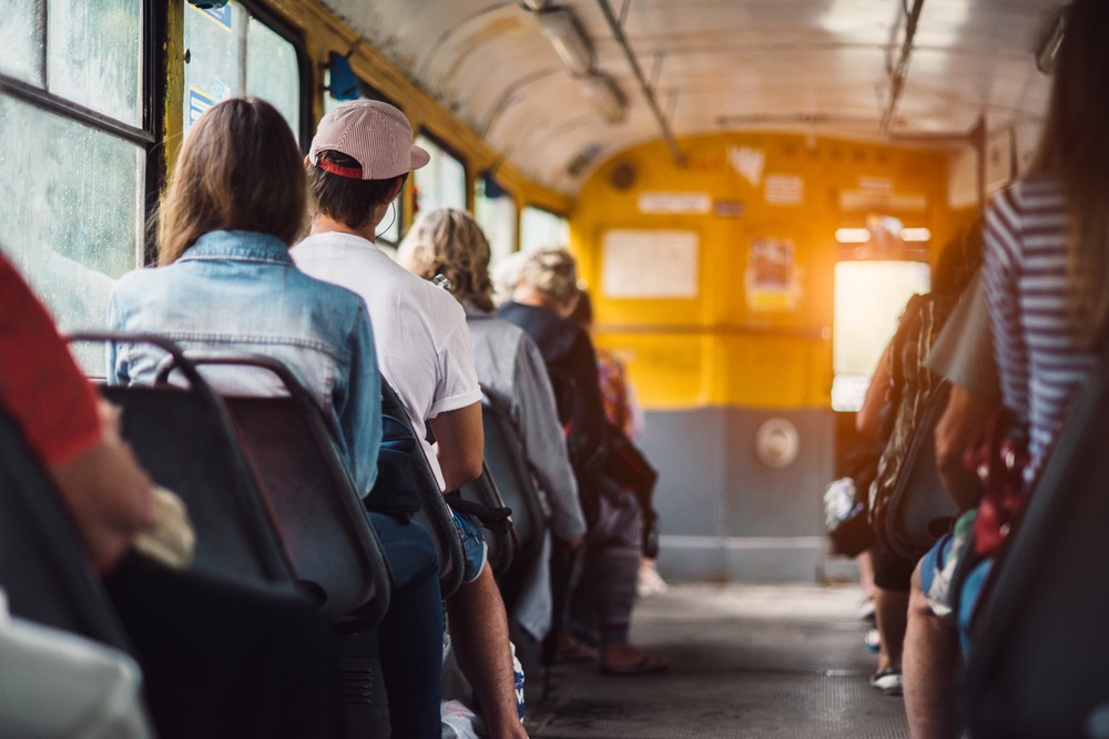 A group of people riding a bus. After a collision, you can contact a Michigan City bus accident lawyer.