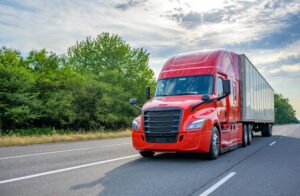 A red semi-truck drives down an Indiana interstate.