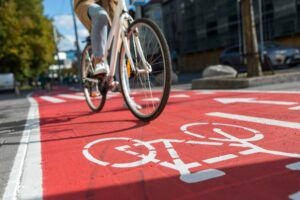 A faceless bicyclist rides their bike in a bike lane.