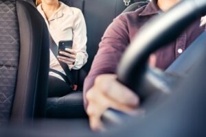 A passenger uses a rideshare app in a Lyft.