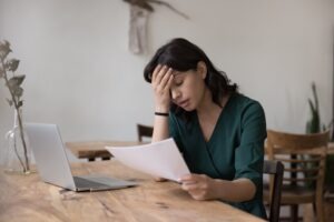 A worried woman wondering how to get compensated if she’s in a car wreck driving for Uber or Lyft.