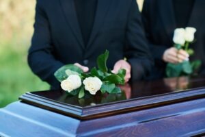 Two people at a funeral. A lawyer can explain how much cases are worth when someone dies in a car accident. 