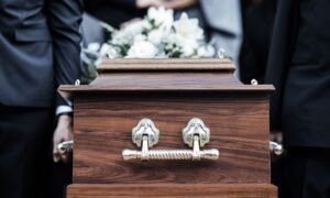 Pallbearers carry a casket at a funeral.