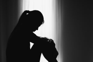 A backlit woman mourns the loss of her mother.