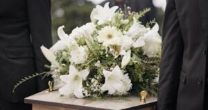 Pallbearers carrying a coffin at a funeral. A lawyer can explain if the insurance company will pay for your spouse’s funeral after a car accident. 