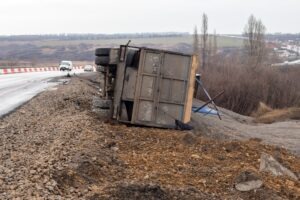 Onlookers drive past a truck flipped on the side of the road as they wonder what the average settlement for a truck accident in Indiana is.