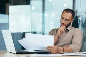 A man looking at paperwork and wondering, “What are lawyer fees for a truck accident?”