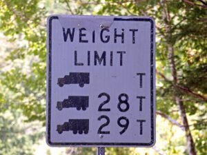 A sign showing different commercial truck weight limits for a bridge based on the number of axles of the truck.