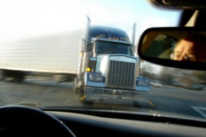 A truck and a passenger vehicle prepare for a head-on collision. Improper turning is one of the most common truck accident causes in Indiana.