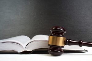 A law book and a gavel on a table. Concept image regarding the trucking laws in Indiana.