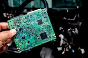 A person holding the circuit board of a commercial vehicle onboard computer.