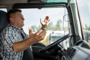 Truck driver in the cabin of a vehicle after a crash and wondering how the other driver can hold their trucking company liable for an accident