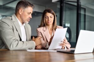 Attorney sitting with a client at a desk and explaining what board certified means for a lawyer