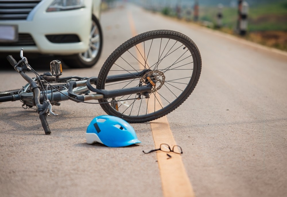 Bicycle and helmet knocked to the ground after being struck by a car in Indianapolis representing cyclist accident liability and the legal rights of injured riders